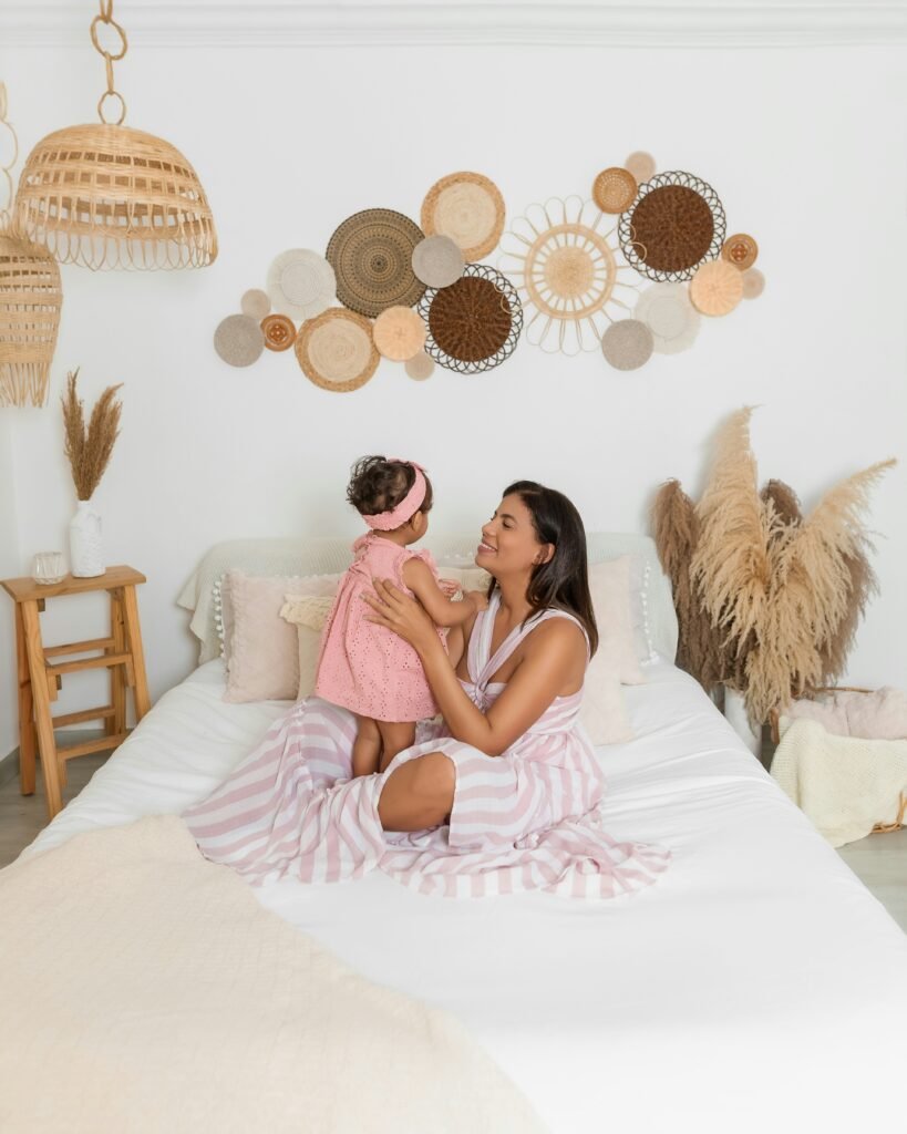 a woman sitting on a bed holding a little girl