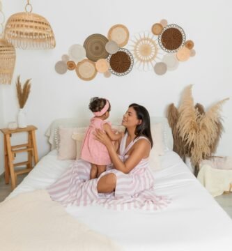 a woman sitting on a bed holding a little girl